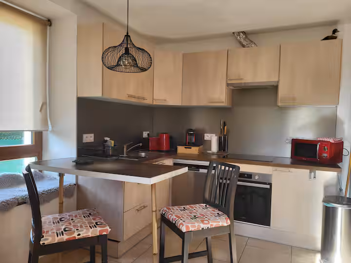 La cuisine équipée, avec four, plaques de cuisson et coin repas